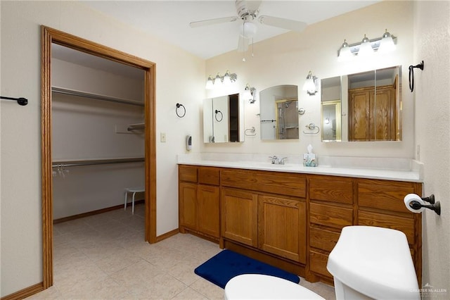 501 Capricorn St, Mission, TX 78572 - bathroom featuring tile patterned flooring, toilet, vanity, a ceiling fan, and a walk in closet