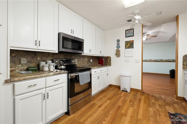 501 Capricorn St, Mission, TX 78572 - kitchen with decorative backsplash, white cabinetry, light wood-style floors, and appliances with stainless steel finishes