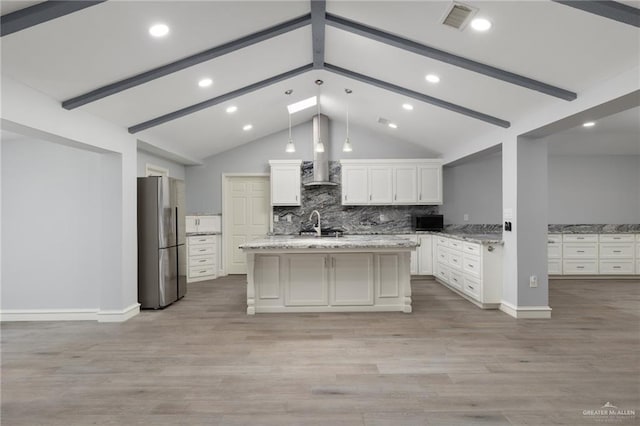 106 E Ithaca Ave, Mcallen, TX 78501 - kitchen featuring freestanding refrigerator, wall chimney range hood, white cabinets, decorative backsplash, and light wood-style flooring