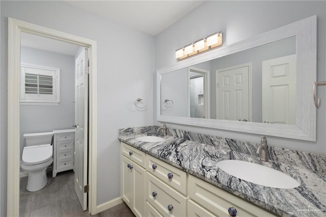 106 E Ithaca Ave, Mcallen, TX 78501 - bathroom with double vanity, wood finished floors, toilet, and baseboards