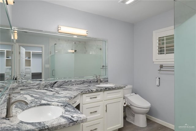 106 E Ithaca Ave, Mcallen, TX 78501 - full bath featuring a shower stall, double vanity, wood finished floors, toilet, and a walk in closet