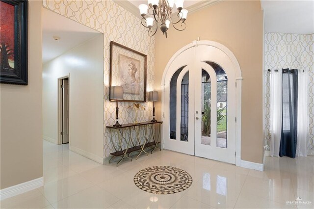 706 Chelsea Ln, Mission, TX 78573 - tiled foyer entrance featuring an inviting chandelier, french doors, wallpapered walls, baseboards, and arched walkways