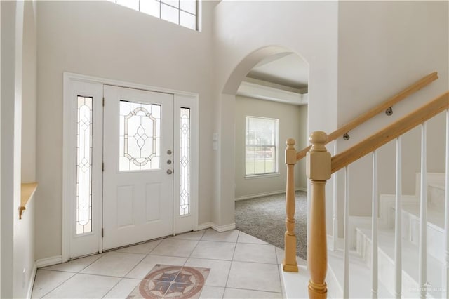 1711 Solar Dr, Mission, TX 78574 - foyer featuring arched walkways, light tile patterned flooring, baseboards, stairs, and a towering ceiling