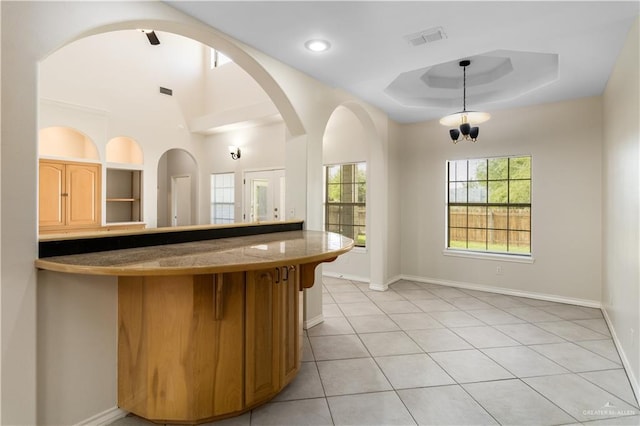 1711 Solar Dr, Mission, TX 78574 - kitchen with plenty of natural light, a breakfast bar, light tile patterned flooring, and baseboards
