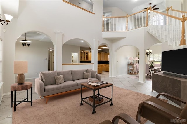 1711 Solar Dr, Mission, TX 78574 - living room featuring light tile patterned flooring, arched walkways, a towering ceiling, a ceiling fan, and baseboards