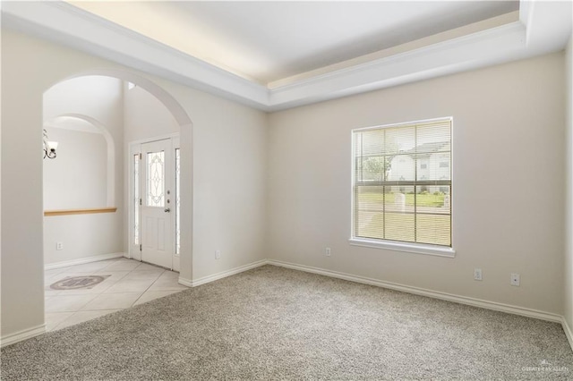 1711 Solar Dr, Mission, TX 78574 - tiled spare room featuring carpet flooring, arched walkways, a raised ceiling, and baseboards