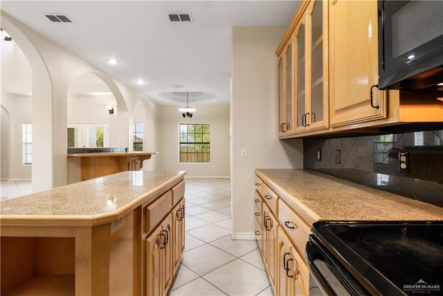 1711 Solar Dr, Mission, TX 78574 - kitchen featuring black microwave, light tile patterned flooring, arched walkways, baseboards, and recessed lighting