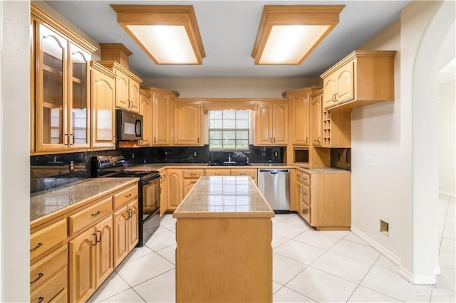 1711 Solar Dr, Mission, TX 78574 - kitchen with black appliances, glass insert cabinets, decorative backsplash, and tile counters