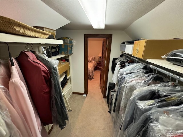 spacious closet featuring lofted ceiling and light carpet