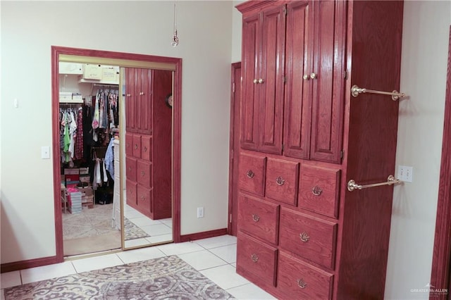 tiled bedroom featuring a spacious closet and a closet