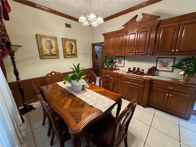 dining room featuring ornamental molding, light tile patterned floors, and an inviting chandelier