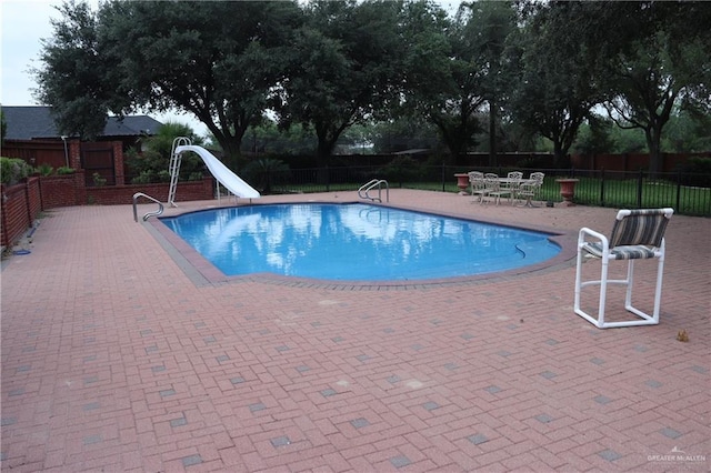 view of pool featuring a patio and a water slide