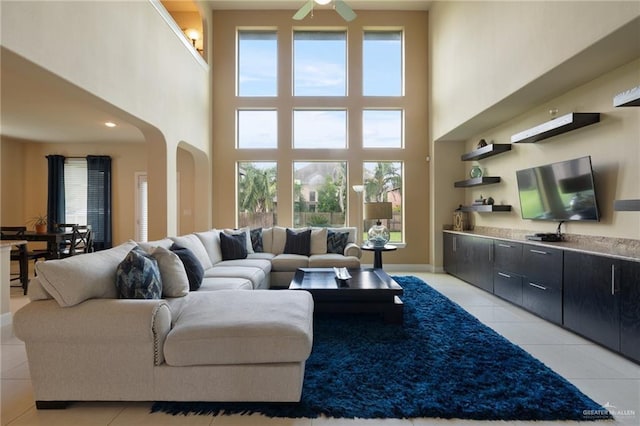 3502 Plantation Grove Blvd, Mission, TX 78572 - living area with light tile patterned floors, a towering ceiling, a ceiling fan, and arched walkways