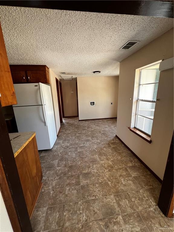 kitchen with a textured ceiling and white refrigerator