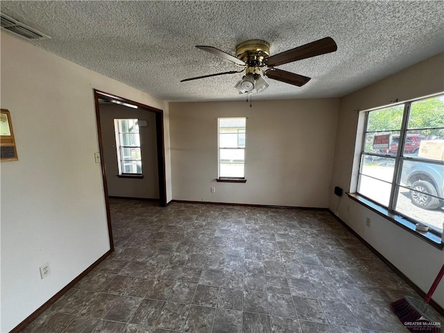 spare room with a textured ceiling and ceiling fan