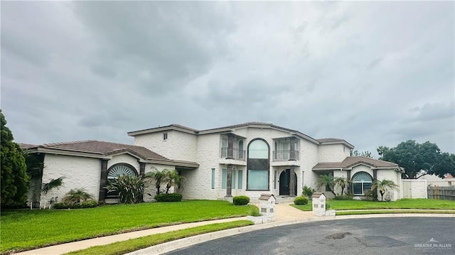 5501 N 8th St, Mcallen, TX 78504 - view of front of property with a front lawn, a balcony, and stucco siding