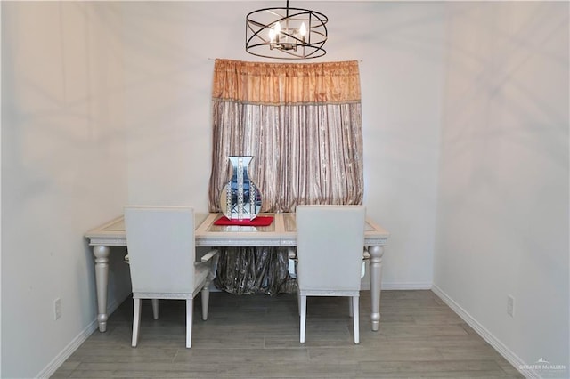 dining space featuring wood-type flooring and a chandelier