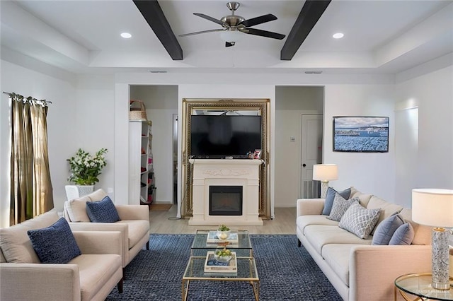 living room featuring beamed ceiling, ceiling fan, and light hardwood / wood-style flooring