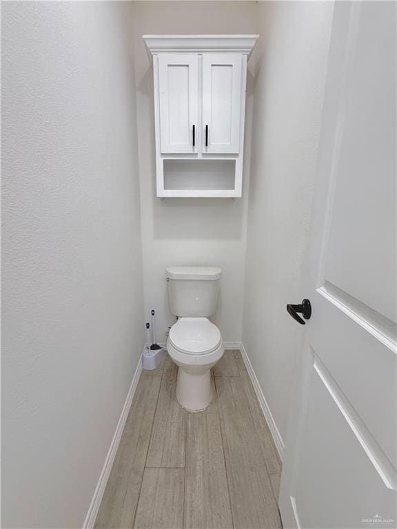 bathroom with hardwood / wood-style flooring and toilet