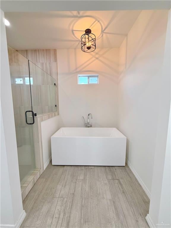 bathroom featuring hardwood / wood-style flooring and plus walk in shower