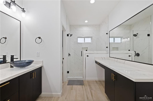 bathroom with wood-type flooring, vanity, and a shower with shower door