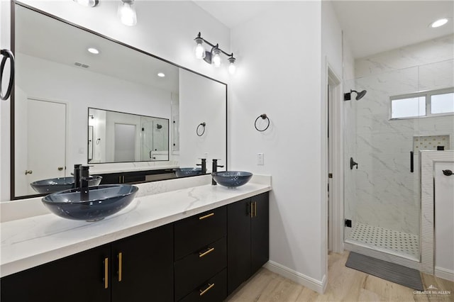 bathroom with hardwood / wood-style floors, vanity, and walk in shower