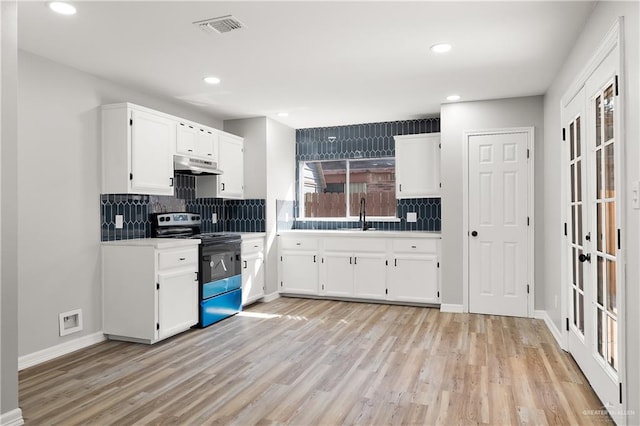 kitchen featuring white cabinets, range with electric stovetop, backsplash, and light hardwood / wood-style flooring