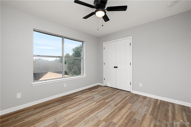 unfurnished bedroom with ceiling fan, a closet, and light hardwood / wood-style flooring