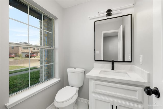 bathroom featuring vanity, toilet, and plenty of natural light