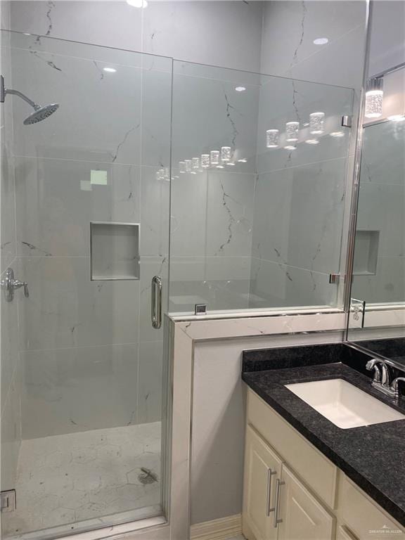 bathroom with a shower with door and vanity