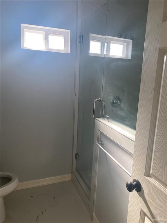 bathroom featuring concrete floors, toilet, and a shower with shower door