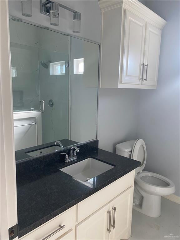 bathroom with vanity, toilet, and an enclosed shower