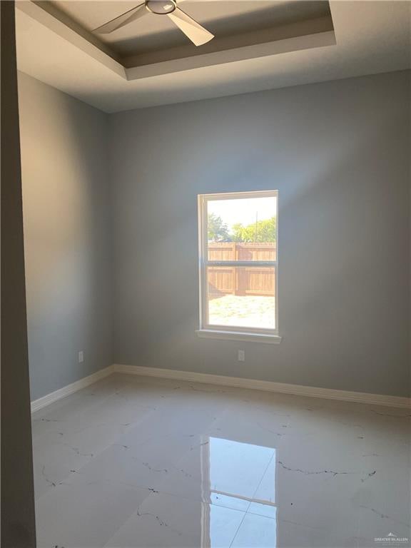 unfurnished room with a raised ceiling and ceiling fan