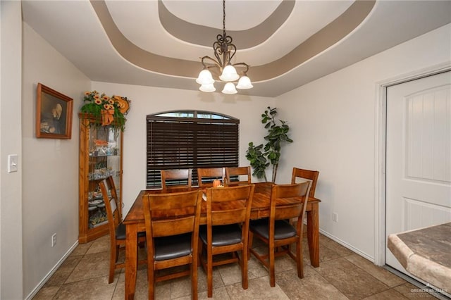 dining room with a tray ceiling and an inviting chandelier