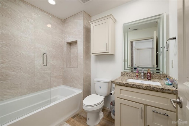 full bathroom featuring toilet, wood-type flooring, vanity, and shower / bathtub combination