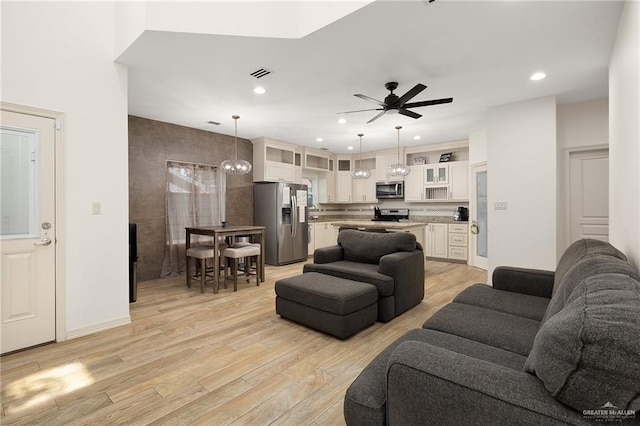 living room with light wood-type flooring and ceiling fan