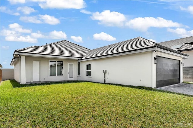 rear view of property featuring a yard and a garage