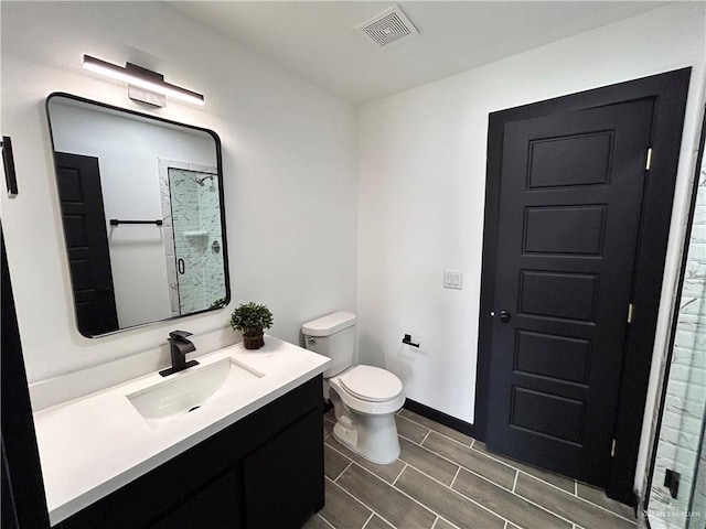 full bath with vanity, baseboards, visible vents, a stall shower, and toilet