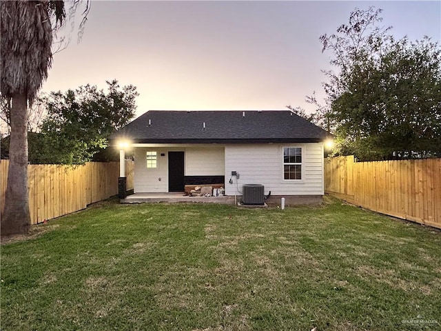 back of house featuring a patio, a yard, a fenced backyard, and cooling unit