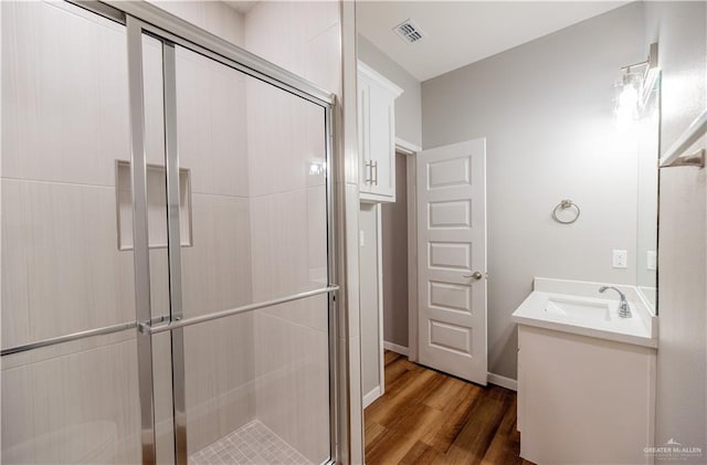 bathroom with vanity, wood-type flooring, and a shower with door