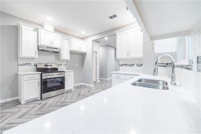 kitchen with white cabinets, light parquet flooring, sink, and stainless steel stove