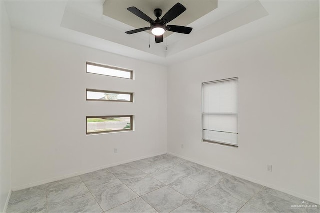 unfurnished room featuring ceiling fan and a tray ceiling