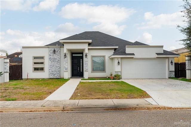 prairie-style home featuring a garage and a front lawn