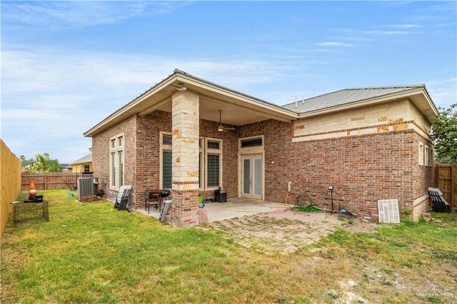 rear view of house with a lawn, a patio area, and central AC unit