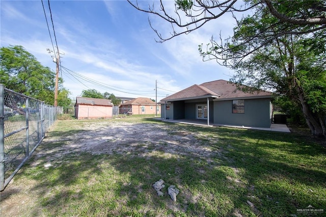 201 E Durango Dr, Pharr, TX 78577 - rear view of house featuring a yard, a patio area, a fenced backyard, and stucco siding