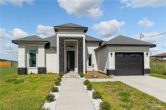 prairie-style home featuring a garage and a front lawn