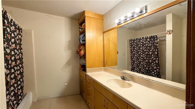 full bath with shower / tub combo, tile patterned floors, vanity, and baseboards