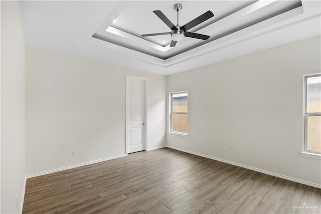 3317 Yellowhammer Ave, Mcallen, TX 78504 - unfurnished room featuring a tray ceiling, wood finished floors, ceiling fan, and baseboards