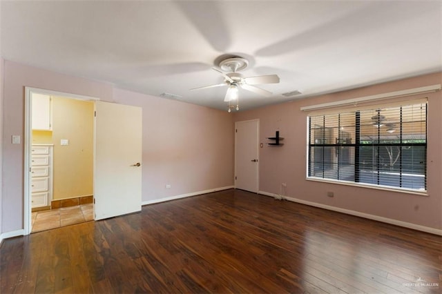 empty room with ceiling fan and dark hardwood / wood-style flooring