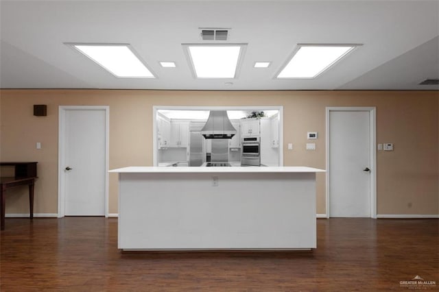 kitchen featuring a breakfast bar area, white cabinets, dark wood-type flooring, and stainless steel appliances